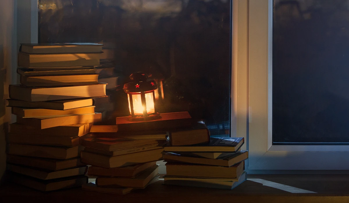 pile of books with lantern on top