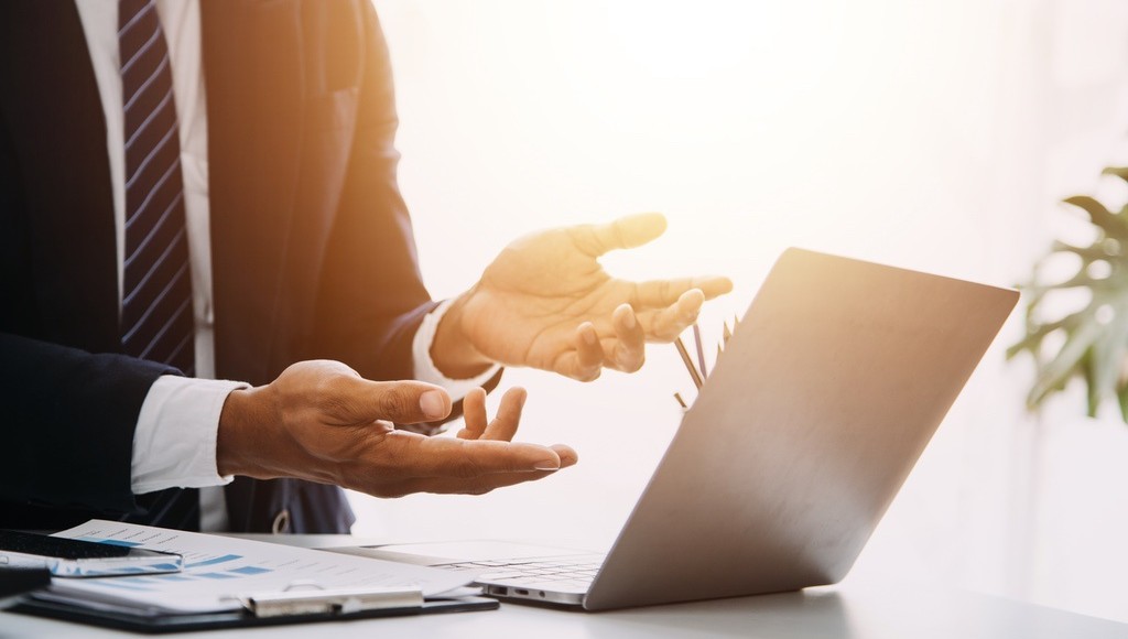 Man in suit making confused gesture at laptop to symbolize ineffective Google Business Profile review strategy