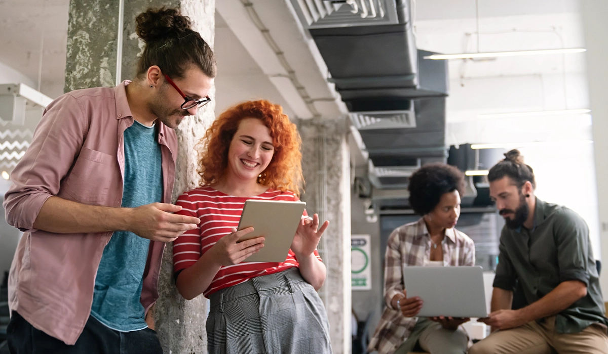 Individuals talking looking at mobile tablet