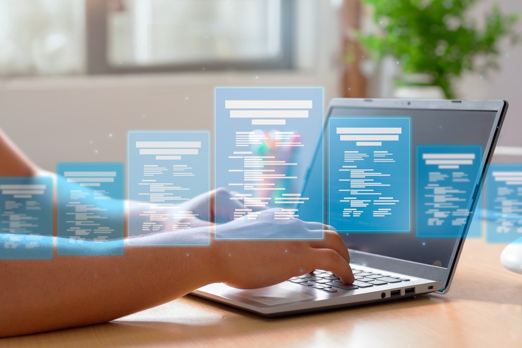 Graphic of information overlaid on person typing at laptop to represent structured data